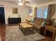 Bright living room features wood floors, a plush sofa with throw pillows, and a large area rug at 816 Polo Park East Blvd, Davenport, FL 33897