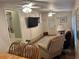 Open concept living room and dining area featuring hardwood floors, multiple ceiling fans, and a large TV at 816 Polo Park East Blvd, Davenport, FL 33897