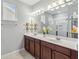 Bright bathroom featuring a double vanity with white countertop, modern lighting fixtures, and a glass-enclosed shower at 8160 Iron Mountain Trl, Windermere, FL 34786