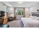 A comfortable bedroom with neutral tones, a large window, and a cozy reading chair at 8160 Iron Mountain Trl, Windermere, FL 34786