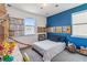 A bedroom featuring a playful blue wall, study area, and large windows for a bright and inviting atmosphere at 8160 Iron Mountain Trl, Windermere, FL 34786