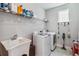 A clean laundry room featuring a utility sink, shelving, a washing machine, and a dryer for convenience at 8160 Iron Mountain Trl, Windermere, FL 34786