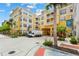 Beautiful yellow condo building with palm trees and well-maintained landscaping at Park North at Cheney Place at 860 N Orange Ave # 323, Orlando, FL 32801