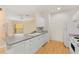 Kitchen with white appliances, white cabinets, a kitchen island, and light hardwood floors at 860 N Orange Ave # 323, Orlando, FL 32801