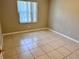 Bedroom with neutral walls, tiled floor, and a window at 9831 Barley Club Dr # 8, Orlando, FL 32837