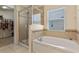 Bathroom featuring a tub and glass enclosed shower with a walk in closet at 10138 Lenox St, Clermont, FL 34711