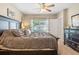 Bedroom featuring a dresser, window and ceiling fan for a comfortable space at 10138 Lenox St, Clermont, FL 34711