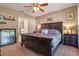 Comfortable bedroom featuring a ceiling fan, dark furniture set and view into the bathroom at 10138 Lenox St, Clermont, FL 34711