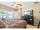 Bedroom featuring a TV, a ceiling fan, neutral walls and ample natural light at 10138 Lenox St, Clermont, FL 34711