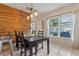 Charming dining area with a wooden accent wall, natural light, and a stylish pendant lighting fixture at 10138 Lenox St, Clermont, FL 34711