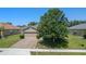 Aerial view of the house, featuring a brick paver driveway, landscaping, and a well-manicured lawn at 10138 Lenox St, Clermont, FL 34711