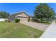 View of the home's front, showcasing the brick paver driveway, and well-maintained lawn at 10138 Lenox St, Clermont, FL 34711
