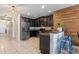 Beautiful kitchen with stainless steel appliances, granite countertops, dark wood cabinets, and a rustic wood accent wall at 10138 Lenox St, Clermont, FL 34711