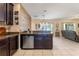 Spacious kitchen with stainless steel dishwasher and sink, granite counters, and an open view to the living area at 10138 Lenox St, Clermont, FL 34711