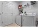 Well-lit laundry room with white washer and dryer units and ample shelving at 10138 Lenox St, Clermont, FL 34711