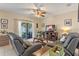 The living room features tile flooring, a ceiling fan, sliding glass doors, and comfortable seating at 10138 Lenox St, Clermont, FL 34711