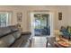 Inviting living room with a comfortable leather sofa, bright natural light, and an access to the screened lanai at 10138 Lenox St, Clermont, FL 34711
