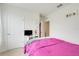 Bedroom with bright pink comforter on bed, and white walls at 11284 Amber Ridge Dr, Zellwood, FL 32798