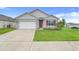 Charming single-story home with a well-maintained lawn and a two-car garage at 11284 Amber Ridge Dr, Zellwood, FL 32798