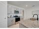 Modern kitchen with stainless steel appliances, granite counters, and grey cabinets at 11284 Amber Ridge Dr, Zellwood, FL 32798