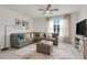 Bright living room featuring a gray sectional sofa, stylish decor, and a ceiling fan at 11284 Amber Ridge Dr, Zellwood, FL 32798