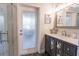 Elegant bathroom features a modern vanity, stylish mirror, and access door to the exterior at 1161 Coastal Cir, Ocoee, FL 34761