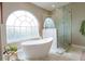 Bathroom with stand alone tub, tiled shower, and large window at 1161 Coastal Cir, Ocoee, FL 34761