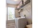 Bright laundry room with modern washer and dryer, wire rack shelving, and natural light from a window at 1161 Coastal Cir, Ocoee, FL 34761