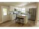 Bright kitchen featuring white cabinets, stainless steel appliances, island with stool seating, and updated fixtures at 1220 Dustin Dr, Lady Lake, FL 32159