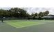 Spacious tennis courts surrounded by trees and benches, ideal for sports and relaxation at 1220 Dustin Dr, Lady Lake, FL 32159