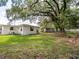 A spacious backyard with green grass and mature trees that give the yard plenty of shade at 1244 Woodland Ave, Lakeland, FL 33801
