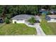 Charming single-story home with pink accents, a covered carport, and a well-maintained lawn and mature landscaping at 1244 Woodland Ave, Lakeland, FL 33801