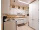 Kitchen featuring white cabinets, matching appliances, and tile flooring at 1244 Woodland Ave, Lakeland, FL 33801