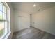 Bright bedroom with gray wood-look flooring and a closet with folding doors at 13420 Sw 77Th Ave, Ocala, FL 34473