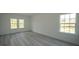 Bright bedroom with gray wood-look flooring and multiple windows at 13420 Sw 77Th Ave, Ocala, FL 34473
