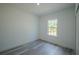 Well-lit bedroom with wood-look flooring, a window with natural light, and fresh paint at 13420 Sw 77Th Ave, Ocala, FL 34473