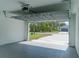 Bright garage showcasing a door opening onto the driveway and a view of the property at 13420 Sw 77Th Ave, Ocala, FL 34473
