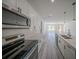 Modern kitchen featuring white cabinets, stainless steel appliances, and an open-concept design leading to the living area at 13420 Sw 77Th Ave, Ocala, FL 34473