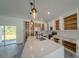 Bright kitchen with white cabinets, stainless steel appliances, a large island, and open shelving at 13420 Sw 77Th Ave, Ocala, FL 34473