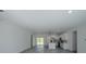 An open-concept living space with sleek floors adjacent to modern white kitchen at 13420 Sw 77Th Ave, Ocala, FL 34473