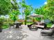Staged backyard with a table, chairs, sofa, umbrella, and rug for relaxing and entertaining at 1408 Watts Ave, Orlando, FL 32809