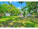 Large, grassy backyard with mature palm trees and a storage shed, perfect for outdoor activities at 1408 Watts Ave, Orlando, FL 32809
