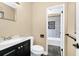Bathroom featuring a stylish vanity, toilet, and an open doorway to the tiled shower and tub at 1408 Watts Ave, Orlando, FL 32809