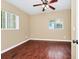 A cozy bedroom with wood-look flooring, a ceiling fan, and bright natural light from two windows at 1408 Watts Ave, Orlando, FL 32809
