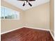 Bedroom featuring wood-look flooring, neutral walls, a ceiling fan, and a window with natural light at 1408 Watts Ave, Orlando, FL 32809
