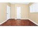 Bright bedroom with wood-look floors, neutral walls, and two doors, one leading to an exterior entrance at 1408 Watts Ave, Orlando, FL 32809
