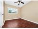 Bedroom featuring wood-look flooring, neutral walls, a ceiling fan, and a window with natural light at 1408 Watts Ave, Orlando, FL 32809