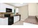 Well lit kitchen featuring white cabinetry, black appliances, stone tile backsplash, and ample counter space at 1408 Watts Ave, Orlando, FL 32809