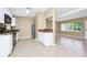 Cozy kitchen with white cabinetry, black appliances, stainless refrigerator, tile floors, and adjoining living space at 1408 Watts Ave, Orlando, FL 32809
