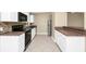 Well lit kitchen featuring white cabinetry, black appliances, stone tile backsplash, and stainless refrigerator at 1408 Watts Ave, Orlando, FL 32809